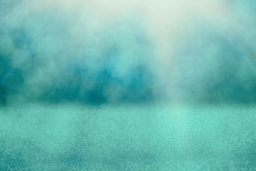 Blue bokeh background for christmas, defocused round lights and sunbeams, flare overlay