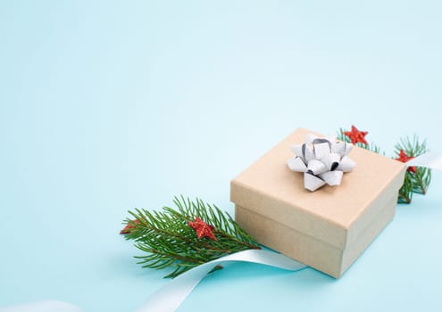 Christmas holiday greeting card with little gift boxes, stars and fir branches, blue background