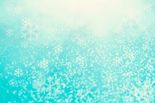 Blue bokeh background with snowflakes for christmas, defocused round lights and sunbeams, flare overlay