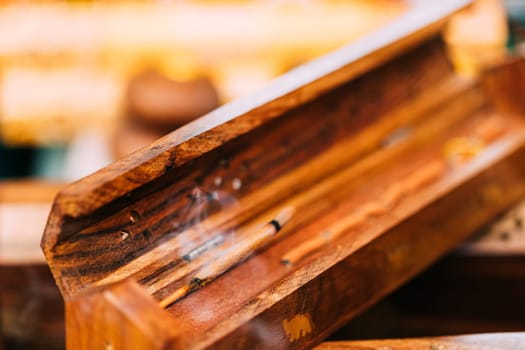 Smoking Burning Incense Aromatic Sticks In Wooden Box Releases Fragrant Smoke. Incense Is Used For Aesthetic Reasons, Aromatherapy, Meditation, And Ceremony.