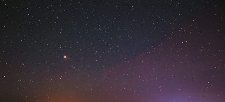 Night Starry Sky With Glowing Stars. Bright Glow Of Planet Venus In Sky Among Stars. Sky In Lights Of Sunset Dawn.