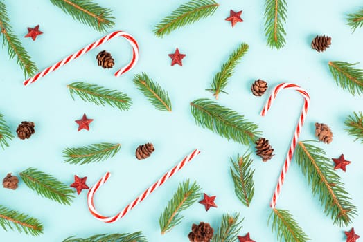 Christmas holiday background with candy cane, fir branches, pine cones and red stars, winter season