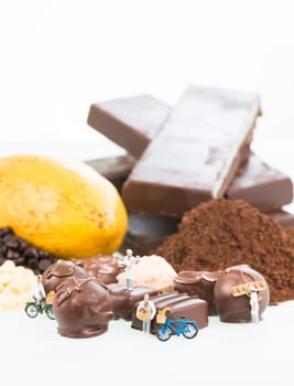 Miniature chefs and cocoa ingredients over white background