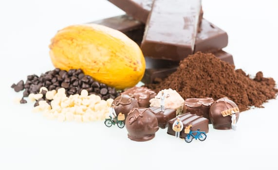 Miniature chefs and cocoa ingredients over white background