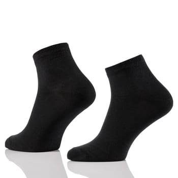 Close up of black cotton short sock on invisible foots isolated on white background. Layout for advertising, branding, design or template.