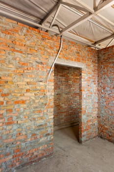 Brickwork. Completed brick wall and door frame of construction site in new residential building. Bare walls ready for plastering. Construction site of private house.