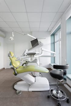 Dentistry. Empty spacious dental office with dental chair and variety of equipment. Interior of dental office with modern dental units, chairs, equipment, tools and lamp used by dentists.