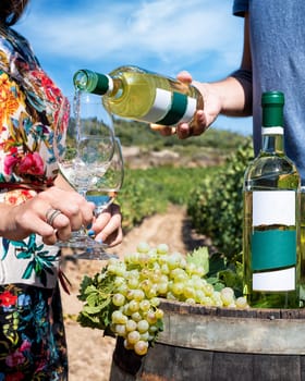 Vermentino wine. Young boy pours white wine into the goblet between the rows of a vineyard. Lifestyle, food and drink.