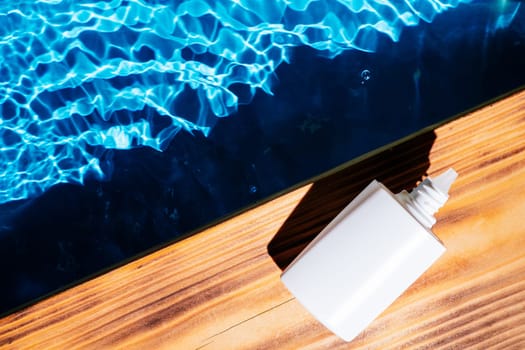 Wood desk with white bottle of nose drops, allergy aerosol for sinusitis cure. Control breath. Blue transparent reflect water surface ocean. Hot warm dry air summer beach. Flat lay. Place for text.