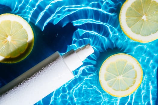White beauty product sunscreen cream vial sprayer in transparent fresh water with flecks and waves, lemon citrus. Body skin care protection sunblock in summer beach travel concept. Flat lay.