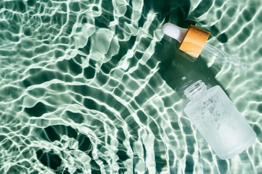 Facial pipette serum, essence cosmetic product in water drop splashing fresh transparent, flecks. Flat lay, top view. Summer beach tropical, vacation. Organic skin body anti age care in hot climate