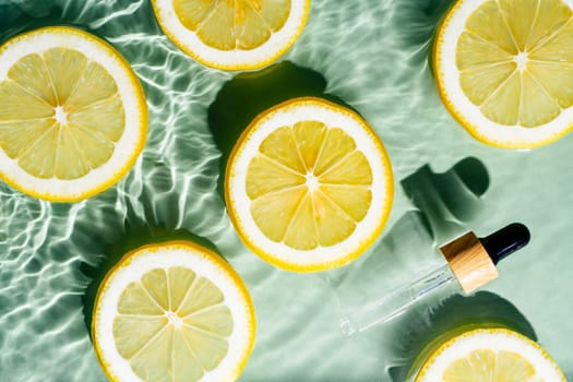 Facial pipette serum, whey beauty product near fruit citrus lemon in water splashing fresh transparent, flecks. Flat lay, top view. Summer beach tropical. Organic skin body antiage care in hot climate