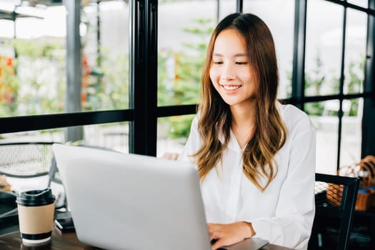 Asian young business woman lifestyle using laptop computer at cafe coffee shop, Happy beautiful freelancer typing keyboard on laptop, working online outside office