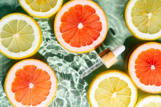 Facial pipette serum, whey beauty product near fruit citrus lemon and grapefruit in water fresh transparent. Flat lay, top view. Summer beach tropical. Organic skin body antiage care in hot climate