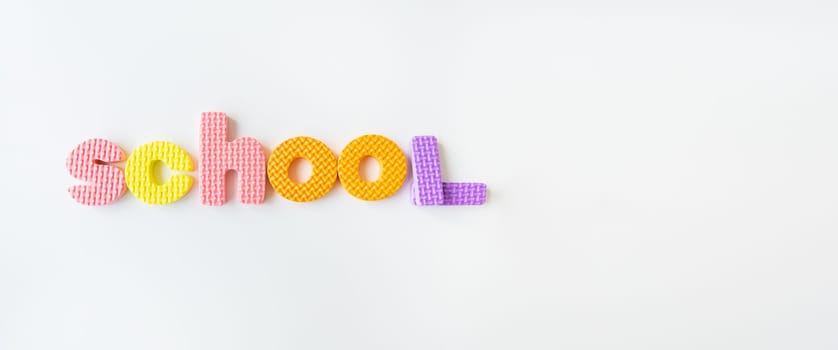 Banner with multi-colored letters. Letters for the study of children in kindergarten or school, fluted letters. School inscription