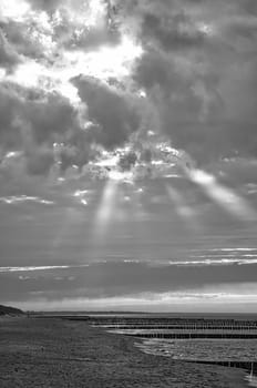 in spring a view over the beach in Zingst on the Baltic Sea. Walk by the sea in black and white. Moving clouds in the sky