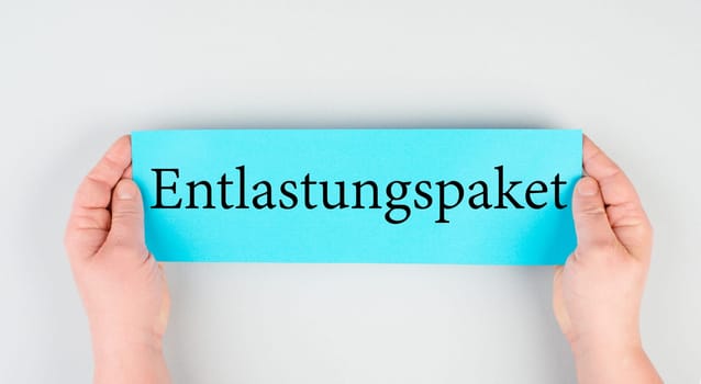 Relief package is standing in german language on the paper, finanical help for energy crisis, increasing prices , high living expenses, gas and electricity costs