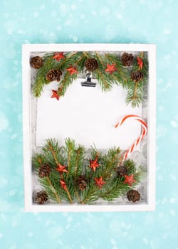 Christmas holiday background, frame with fir branches, stars, candy cane and pine cones, winter season greeting card