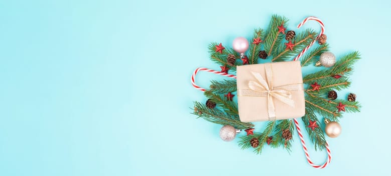 Christmas holiday background, gift box with fir branches, baubles, candy cane and pine cones, winter season greeting card