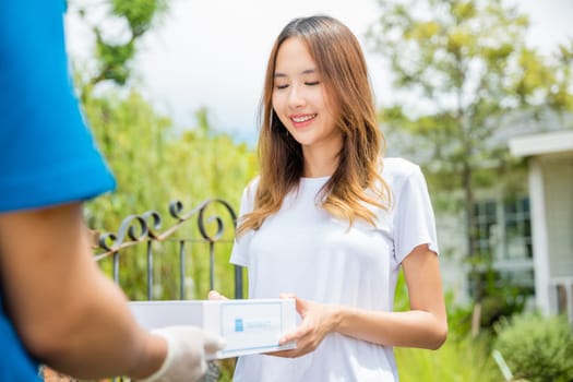 Asian woman sick she receive medication first aid pharmacy box hospital delivery service, Delivery man give medicine drug store to patient female at front home, healthcare medicine online business
