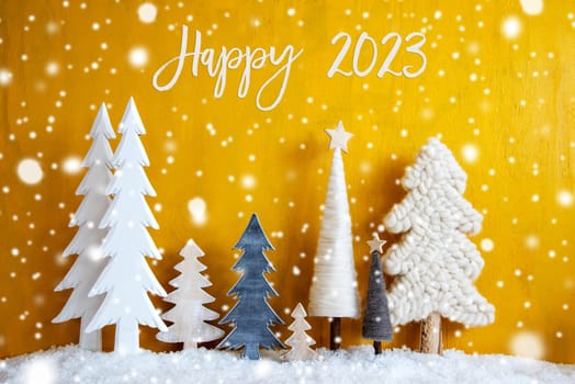 Christmas Trees With English Calligraphy Happy 2023. Yellow Wooden Rustic Background With Snow And Snowflakes. Christmas Decoration With Stars.