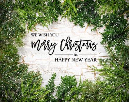 Christmas Card With Fir Branches And English Text Merry Christmas And A Happy New Year. White Wooden Background With Vintage Design And Snowflakes.