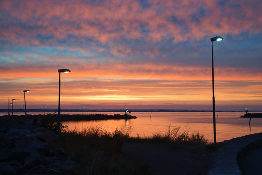 Sunset in Sweden at the harbor of lake Vaettern. Lighthouse in the background at dusk. Landscape shot in Scandinavia.