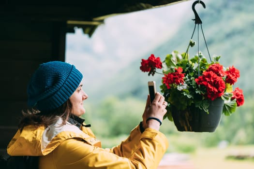 Young Woman Tourist Lady Photographs A Hanging Flower Pot On Phone.