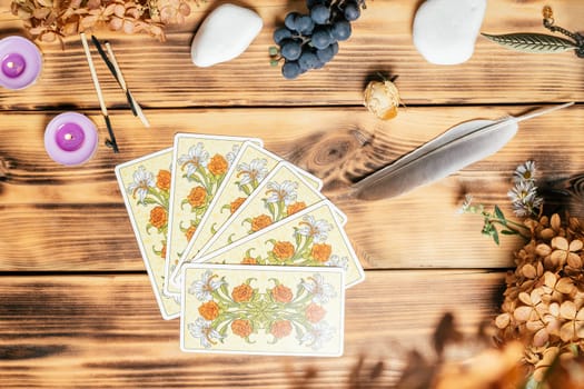 Tarot cards fanned face down on wooden surface with stones, autumn plants and accessories. Top view. Minsk, Belarus, 11.10.2021