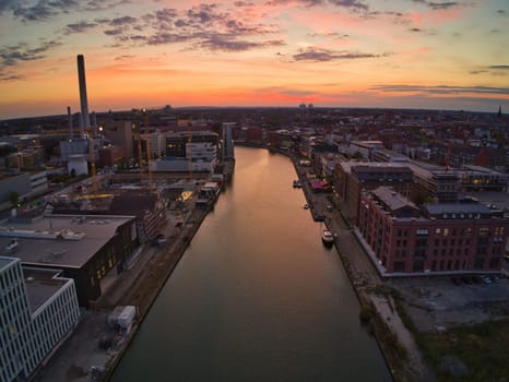 Aerial view of a harbor surrounded by buildings with the evening sun in the background in Muenster, Germany