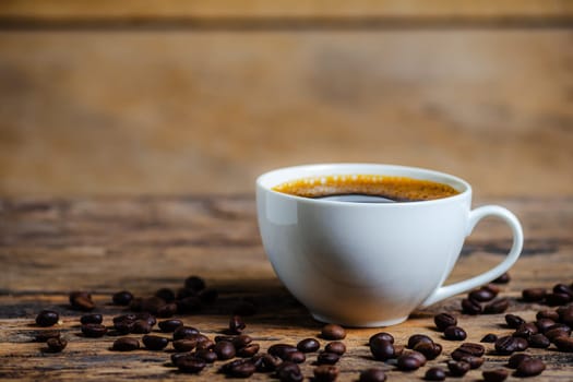 A cup of coffee with coffee bean on wooden background dark tone dtyle