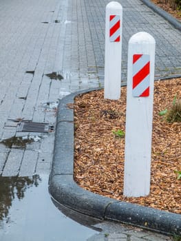 View of a bottleneck with two street bollards on a side street at the port of Harlesiel.