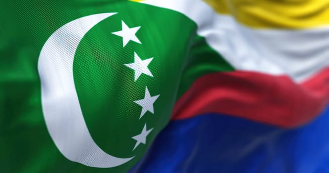 Close-up view of the Comoros national flag waving in the wind. The Union of the Comoros is an archipelagic country in the Indian Ocean. Fabric textured background. Selective focus