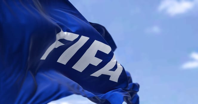 Zurich, SWI, October 2022: Close-up view of the Fifa flag waving in the wind. Fifa is an international governing body of association football, beach football and futsal. Selective focus