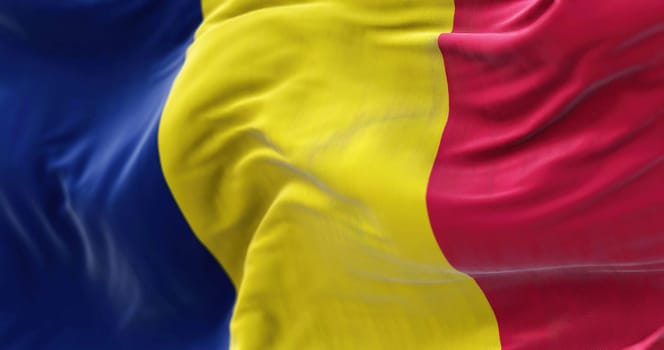 Close-up view of the Chad national flag waving in the wind. The Republic of Chad is a country at the crossroads of North and Central Africa. Fabric textured background. Selective focus