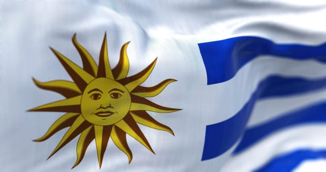 Close-up view of Uruguay national flag waving in the wind. The Oriental Republic of Uruguay is a country in South America. Fabric textured background. Selective focus