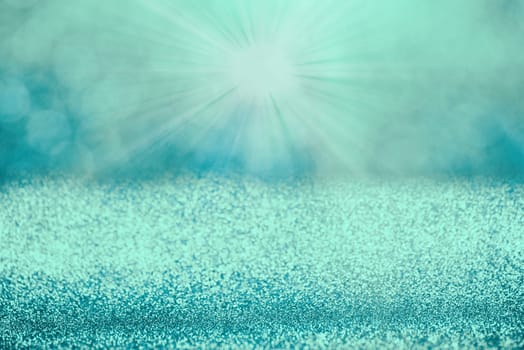 Blue bokeh background for christmas, defocused round lights and sunbeams, flare overlay