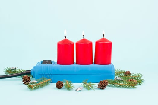 Red christmas candles in a socket, expensive electricity costs, blackout risk in Germany, cold winter with rationing