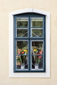 Window of a romantic and colorful house with flower pots.