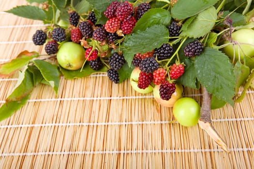 apples and raspberries on a wooden table