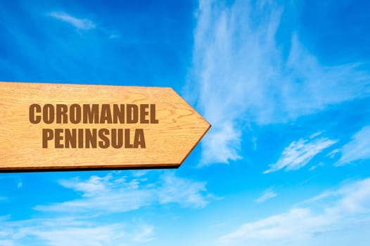 Wooden arrow sign pointing destination COROMANDEL PENINSULA, NEW ZEALAND against clear blue sky with copy space available. Travel destination concept  image