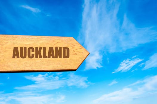Wooden arrow sign pointing destination AUCKLAND,      NEW ZEALAND  against clear blue sky with copy space available. Travel destination concept  image
