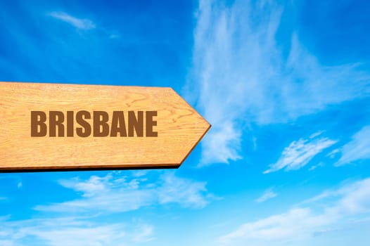 Wooden arrow sign pointing destination BRISBANE, AUSTRALIA  against clear blue sky with copy space available. Travel destination concept  image