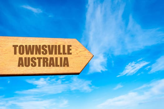 Wooden arrow sign pointing destination TOWNSVILLE, AUSTRALIA  against clear blue sky with copy space available. Travel destination concept  image