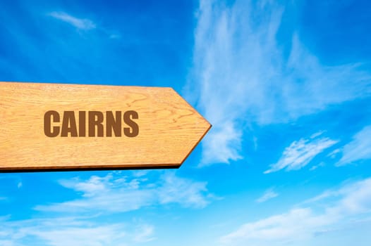 Wooden arrow sign pointing destination CAIRNS, , AUSTRALIA  against clear blue sky with copy space available. Travel destination concept  image