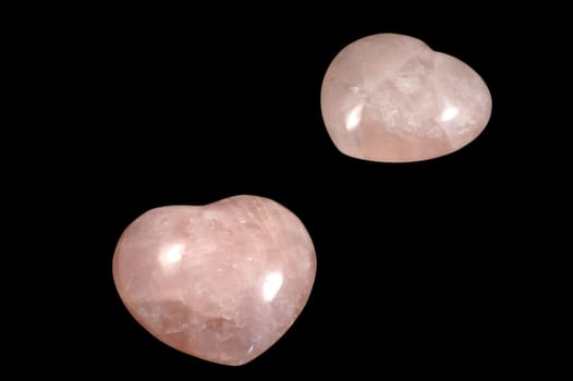 Two pink stoned hearts isolated over black