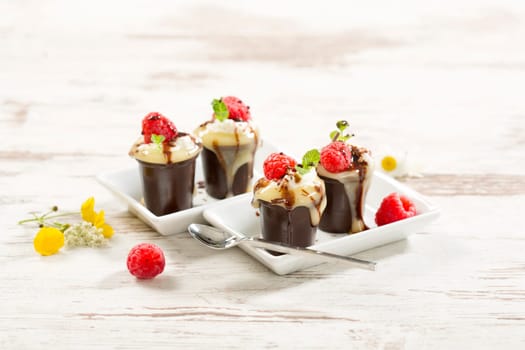 Chocolate cups with vanilla pudding,cream and raspberries