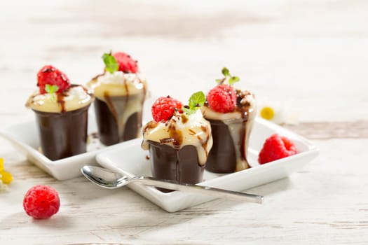 Chocolate cups with vanilla pudding,cream and raspberries