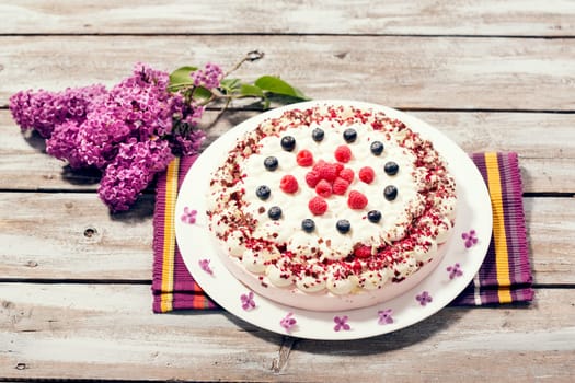 Raspberry cream cake with fresh raspberries and blueberries