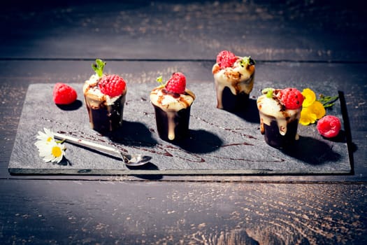 Chocolate cups with vanilla pudding,cream and raspberries